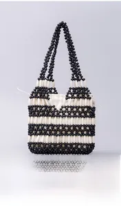 Detail of a handmade beaded handbag featuring contrast wood beads and drawstring liner