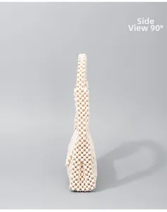 Detailed side view 90-degree angle of ivory hand-woven beaded underarm handbag