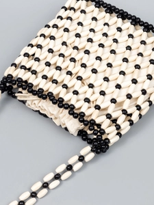 Handwoven black and white beaded crossbody bag with wooden beads and drawstring liner