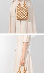 Detailed macro view of handmade wooden bead handbag with white drawstring inner bag