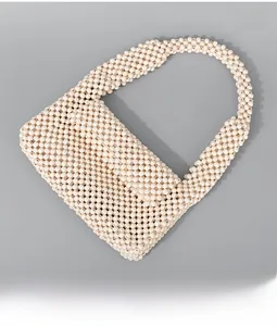 Detailed top view of handmade cream beaded handbag with smooth round resin beads