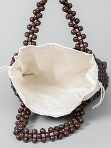 Handmade woven handbag with dark brown wooden beads and a white canvas drawstring pouch
