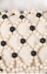 Makro-Detail von handgewebten Holzperlen im Kontrast-Gittermuster auf Umhängetasche