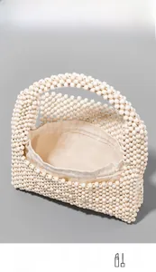 Detail of white beaded handbag with drawstring liner showing storage for phone and wallet