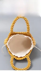 Top view of yellow beaded handbag showing spacious interior with canvas drawstring pouch