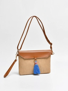 Straw shoulder bag for beach vacation with brown leather flap and blue tassel accent