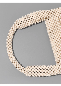 Close-up of cream handmade wooden bead weaving detail on a minimalist underarm bag