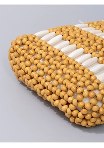 Detailed close-up of handmade maple wood beads on a woven bohemian style handbag