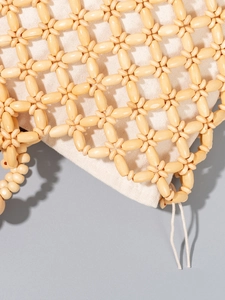 Handmade woven handbag with wooden beads and fabric lining in natural bohemian style