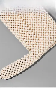 Detail of handcrafted cream wood beads showing natural texture and woven structure