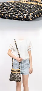 Detailed view of handmade woven bag with black and wooden beads and mesh grid pattern