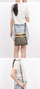 Detail of bohemian hand-woven beaded crossbody bag with geometric wood bead patterns
