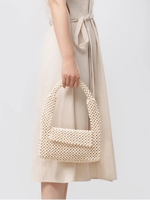 Detailed view of handmade cream beaded shoulder bag with textured woven flap and strap