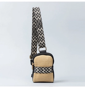 Close-up of woven crossbody bag with black leather trim and jacquard wide strap