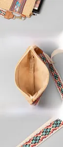 Detail showing the spacious interior and bohemian jacquard strap of the woven straw bag