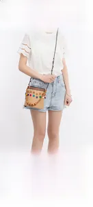 Close-up of bohemian straw bucket bag featuring ethnic embroidery and colorful beadwork