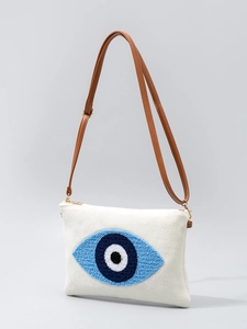 Weiße gewebte Umhängetasche mit blauem Evil-Eye-Stickmuster und braunem Schulterriemen