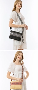 Detail of woven straw clutch with bohemian geometric embroidery and wide shoulder strap