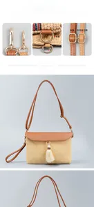 Detail of straw woven shoulder bag with gold hardware and white tassel ornament