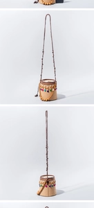 Macro view of woven straw bucket bag featuring colorful wooden beads and bead charms
