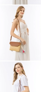 Detail of straw crossbody bag with brown leather flap and colorful tassel accents