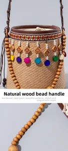 Detail of hand-woven straw bucket bag featuring round wooden bead handle and ethnic charms