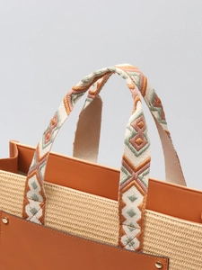 Bohemian straw tote bag with brown leather trim and embroidered geometric handle