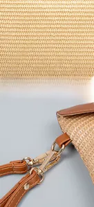 Detailed close-up of straw woven texture with golden hardware and brown leather strap