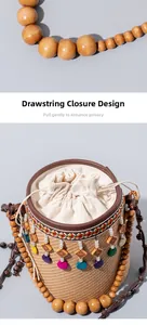 Detail view of woven straw bucket bag with beaded handle and wooden charms