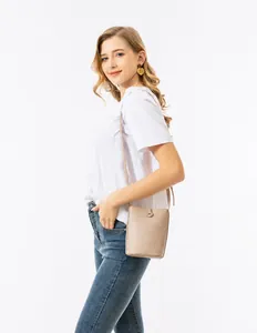 Detalle del bolso tipo cubo de cuero beige con grano de lichi y hebilla metálica de calidad
