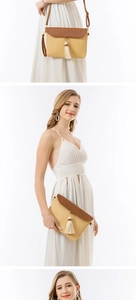 Detail of straw woven envelope bag with brown leather flap and stylish white tassel accents