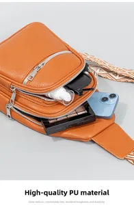 Macro-opname van bruine PU-lederen crossbodytas met etnische band en meerdere ritsvakken