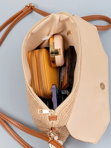 Straw crossbody bag for beach vacations with brown leather strap and spacious interior