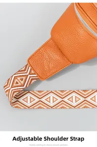 Detail van de verstelbare geweven schouderband op de oranje leer crossbody borsttas