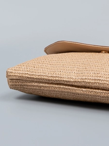 Handwoven straw clutch bag with tan leather trim and golden buckle for beach vacations