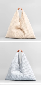Detalle de bolsos triangulares de felpa en crema y gris con asas de cuero