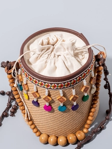 Handmade straw bucket bag with beaded shoulder strap and ethnic charms for beach holidays