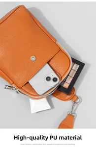 Vista detallada del interior del bolso naranja con textura de lichi, móvil y cosméticos