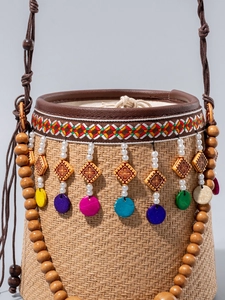 Straw bucket beach bag with colorful bead charms and geometric embroidered trim