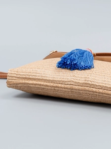 Elegant handwoven straw beach bag with blue tassel charm and brown leather strap for summer