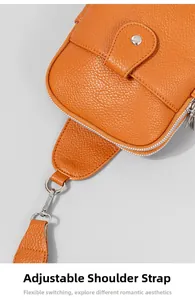Detalle de bolso de pecho naranja en cuero lichi con cremallera y correa ajustable