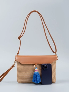 Straw woven shoulder bag with brown leather flap and blue tassel for beach vacations