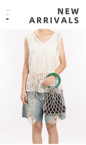 Detail of woven beaded bucket bag with green resin handles and black fabric liner