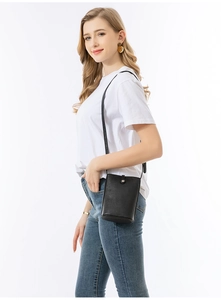 Vista detallada del bolso pequeño de cuero negro en modelo mostrando tamaño y textura