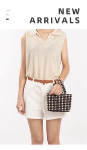 Detail of hand-woven beaded tote bag with contrasting black and cream wooden beads