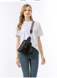 Detalle del bolso bandolera negro con textura de lichi y correa de tejido geométrico