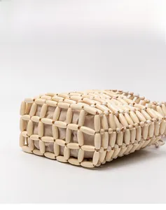Detailed side view of handcrafted hollow wooden bead bag with a cotton linen inner lining