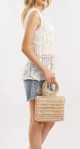 Detailed view of cream-colored beaded handbag with uniform round beads and woven texture