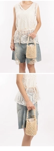 Detail view of a handmade hollow wooden bead bucket bag with a crochet lace summer vest