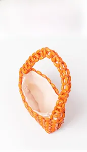 Detail of vibrant orange beaded bag showing woven structure and spacious fabric lining